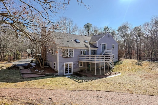 back of house featuring a yard, french doors, roof with shingles, a wooden deck, and a chimney