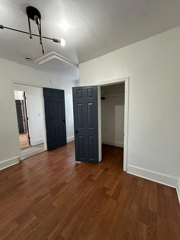 99 Allston St, Lawrence, MA 01841 - unfurnished bedroom featuring baseboards, attic access, dark wood-style flooring, a closet, and a spacious closet