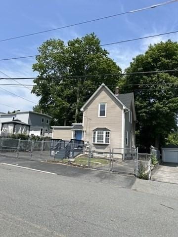 99 Allston St, Lawrence, MA 01841 - view of front facade with a gate and a chimney