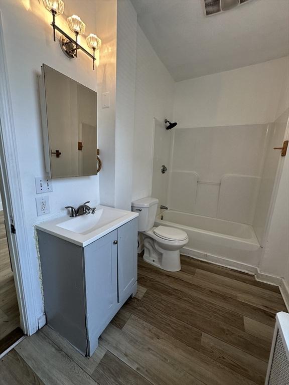 99 Allston St, Lawrence, MA 01841 - bathroom with vanity, wood finished floors, toilet, and shower / bathtub combination