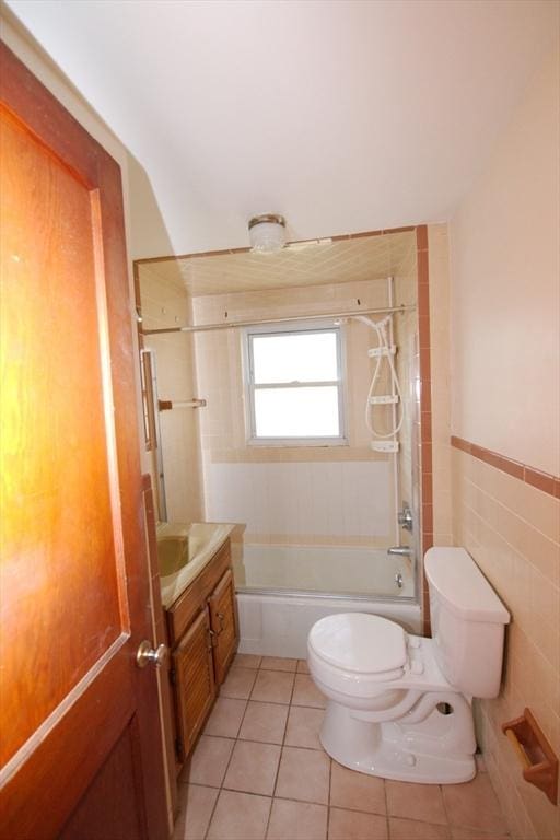 bathroom with toilet, tile walls, vanity, shower / bath combination, and tile patterned floors
