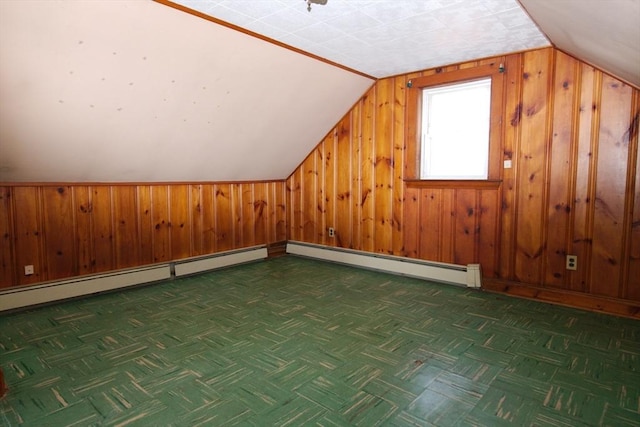 bonus room with a baseboard heating unit, wooden walls, and lofted ceiling