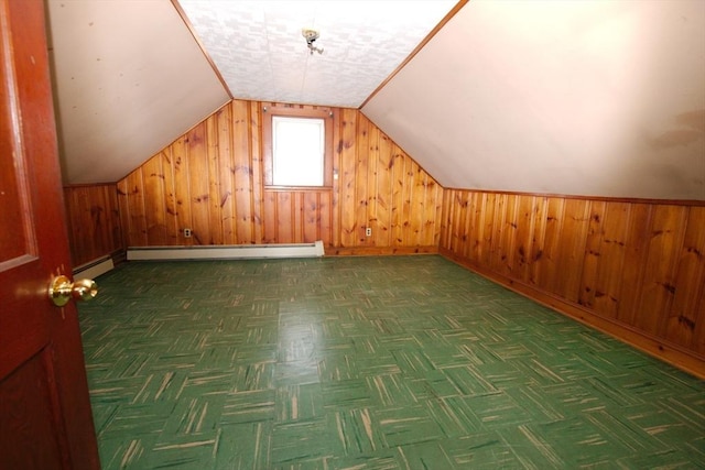 bonus room featuring baseboard heating, wood walls, baseboards, and vaulted ceiling
