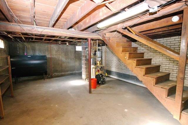 basement featuring heating fuel and stairway