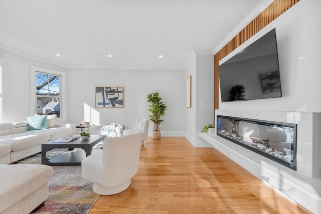 living room with a fireplace, light hardwood / wood-style floors, and crown molding