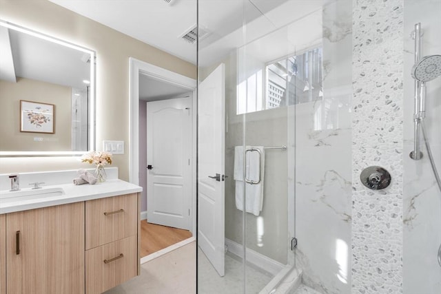 bathroom featuring hardwood / wood-style floors, vanity, and walk in shower