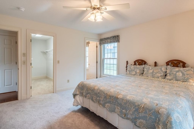 carpeted bedroom with a closet, ceiling fan, and a spacious closet