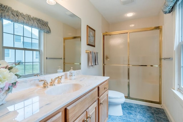 bathroom featuring vanity, a shower with shower door, and toilet