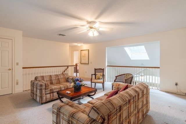 carpeted living room with a skylight and ceiling fan