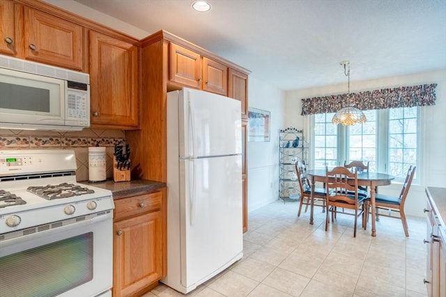 kitchen featuring decorative light fixtures, white appliances, decorative backsplash, and a notable chandelier