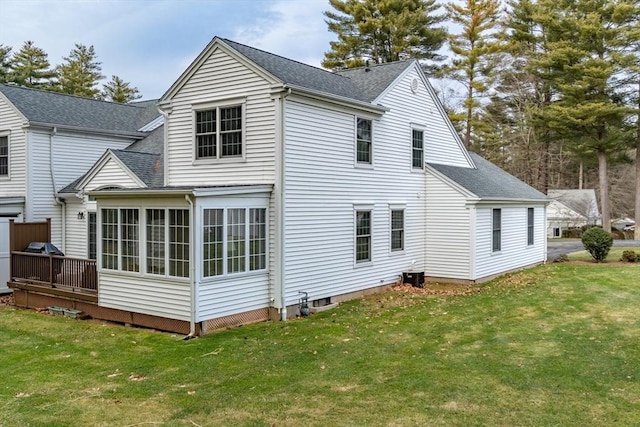 rear view of house with a deck, central AC unit, a lawn, and a sunroom