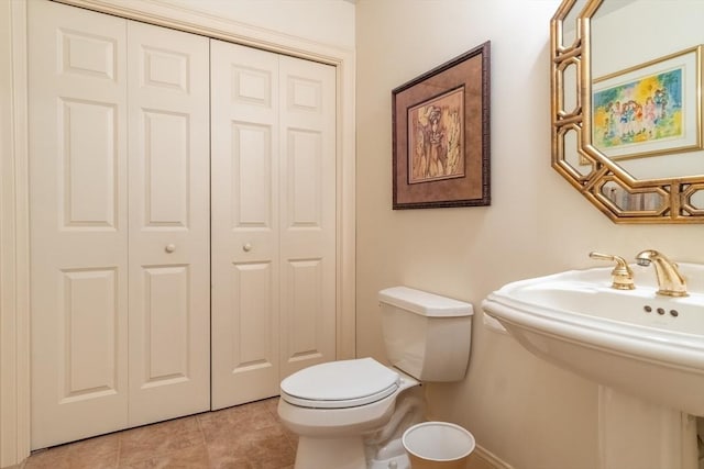 bathroom featuring toilet, tile patterned flooring, and sink