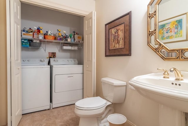 bathroom with sink, tile patterned flooring, independent washer and dryer, and toilet