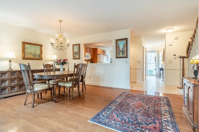 dining space with a chandelier and light hardwood / wood-style flooring