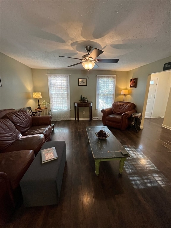 living room featuring a textured ceiling, ceiling fan, and dark hardwood / wood-style floors