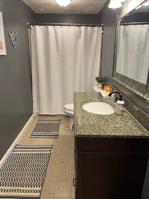 bathroom featuring tile patterned flooring, vanity, toilet, and a textured ceiling