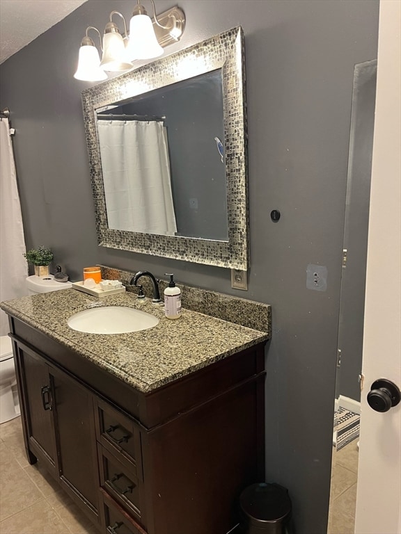 bathroom with tile patterned flooring, vanity, and toilet