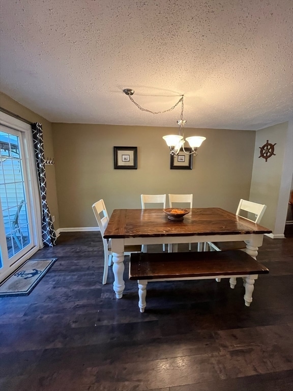 dining room featuring a notable chandelier, a textured ceiling, and dark wood-type flooring