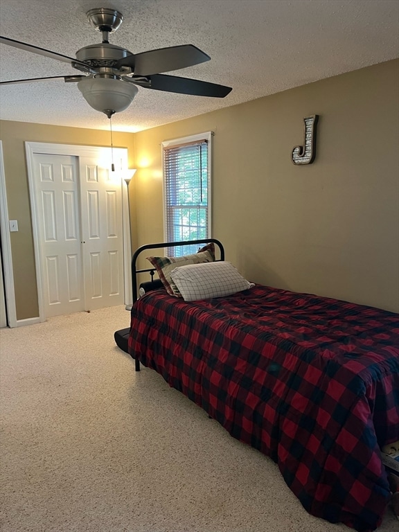 bedroom featuring ceiling fan, a textured ceiling, and a closet