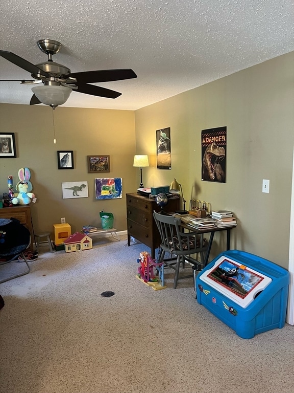 rec room with carpet flooring, ceiling fan, and a textured ceiling