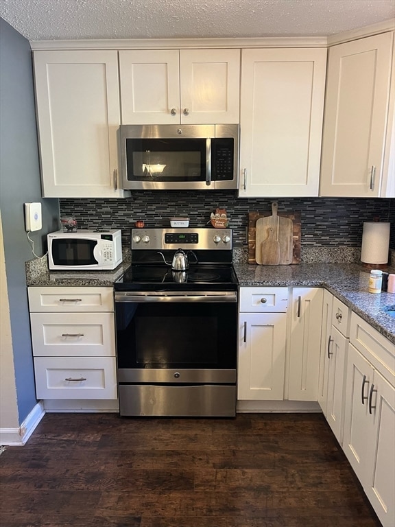 kitchen with white cabinets, dark hardwood / wood-style flooring, stainless steel appliances, and tasteful backsplash