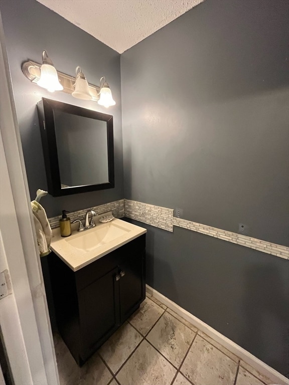 bathroom featuring a textured ceiling and vanity