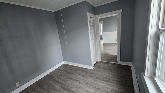 spare room featuring a textured ceiling, dark hardwood / wood-style floors, a wealth of natural light, and crown molding