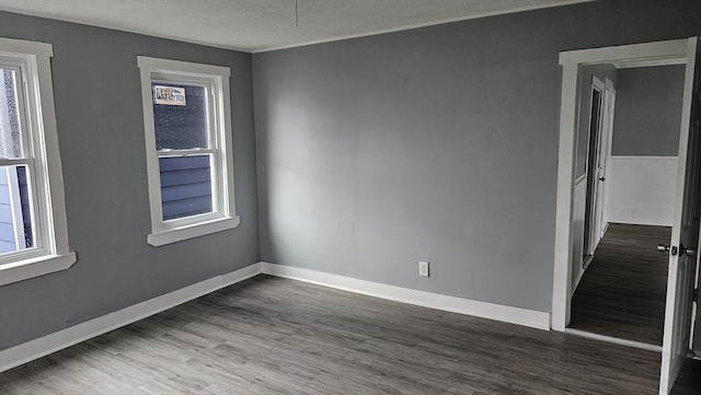 spare room featuring wood-type flooring and a textured ceiling