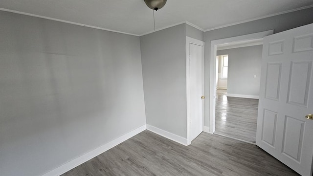 spare room with hardwood / wood-style floors and crown molding