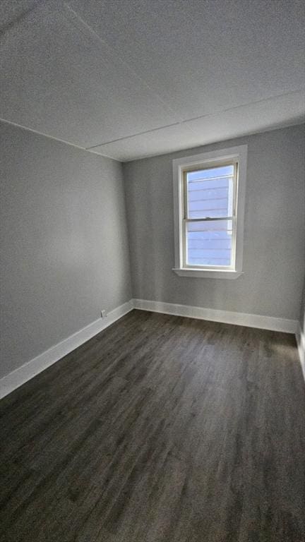 unfurnished room featuring a textured ceiling and dark wood-type flooring