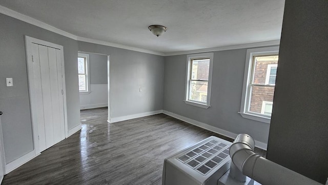 spare room with crown molding and dark wood-type flooring