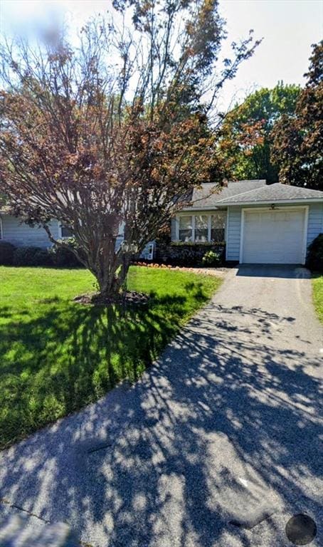 view of front of house with a garage, driveway, and a front yard