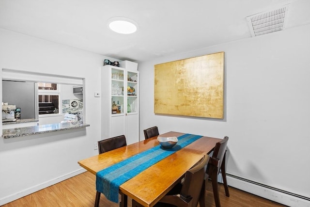 301 Neponset St Unit 12A, Norwood, MA 02062 - dining area featuring a baseboard heating unit, wood finished floors, and baseboards
