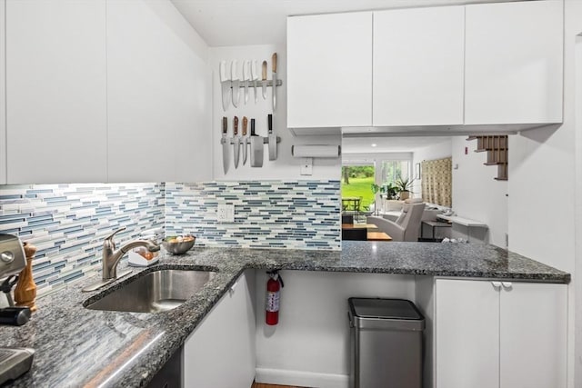 301 Neponset St Unit 12A, Norwood, MA 02062 - kitchen with a sink, white cabinetry, tasteful backsplash, and dark stone countertops