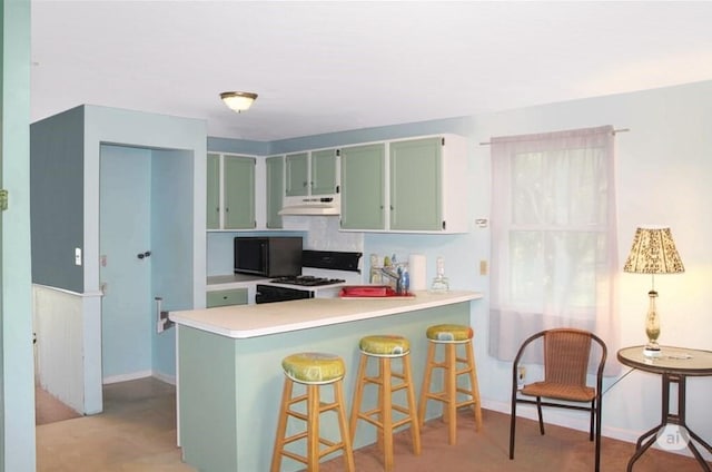 59 Katherine St, Weymouth, MA 02191 - kitchen with under cabinet range hood, green cabinets, gas range gas stove, light countertops, and a peninsula