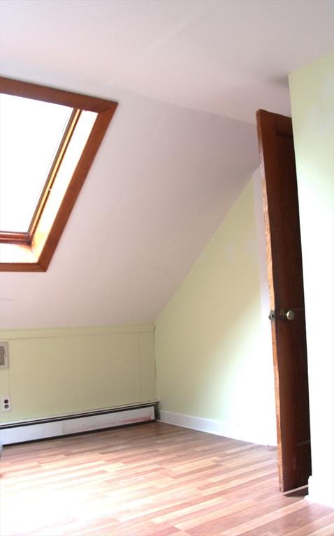 59 Katherine St, Weymouth, MA 02191 - additional living space with a baseboard radiator, lofted ceiling, light wood finished floors, a skylight, and baseboards