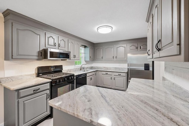 kitchen with black appliances, gray cabinets, a sink, and a peninsula