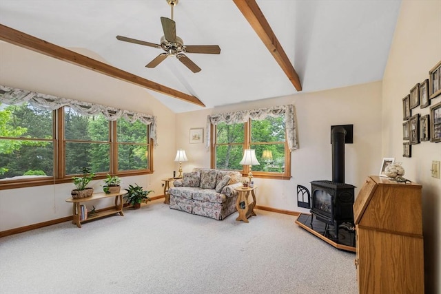 living area with carpet, baseboards, a wood stove, and ceiling fan