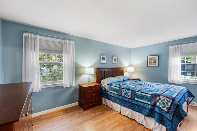 bedroom featuring light wood-style floors and baseboards