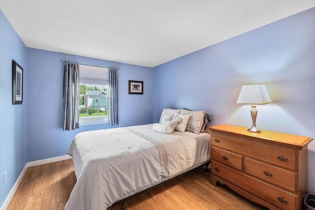 bedroom featuring wood finished floors and baseboards