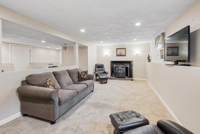 carpeted living room featuring baseboards, recessed lighting, and a fireplace