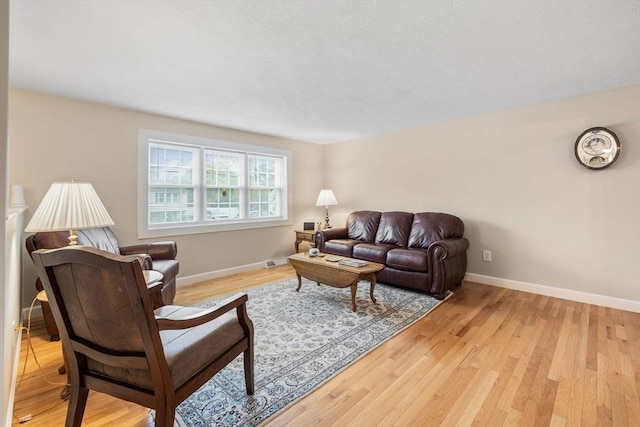 living area featuring light wood finished floors and baseboards