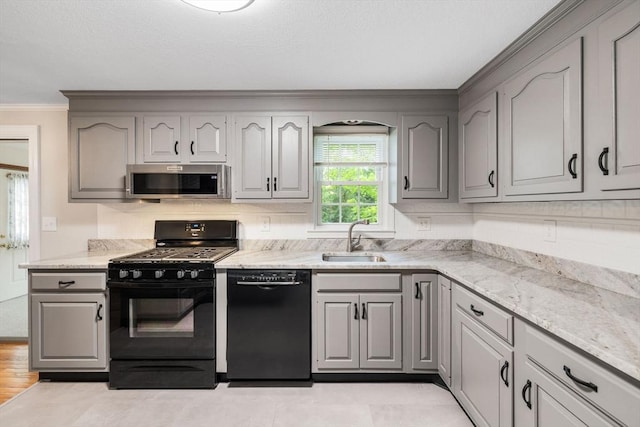 kitchen with black appliances, a sink, gray cabinets, and crown molding