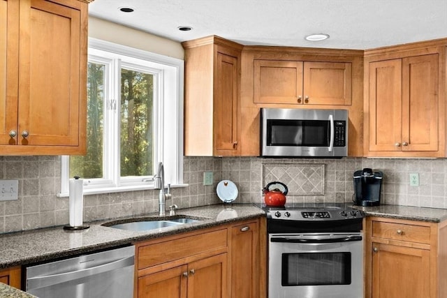 kitchen featuring dark stone countertops, sink, tasteful backsplash, and stainless steel appliances