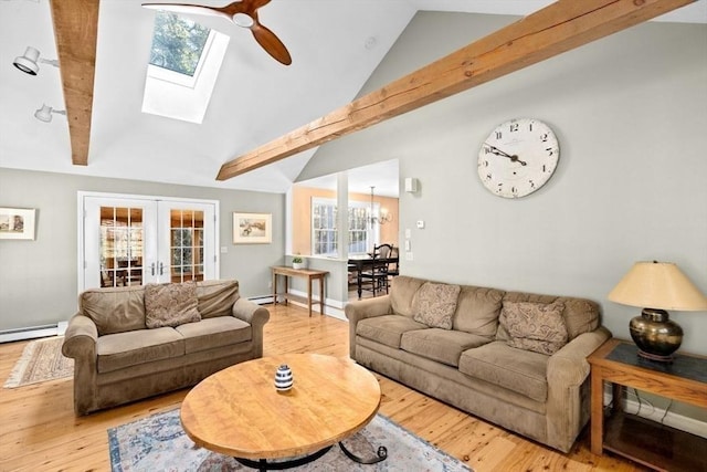 living room featuring french doors, lofted ceiling with skylight, a baseboard radiator, hardwood / wood-style flooring, and ceiling fan with notable chandelier