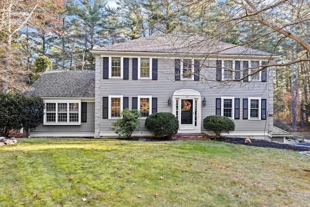 colonial-style house featuring a front lawn