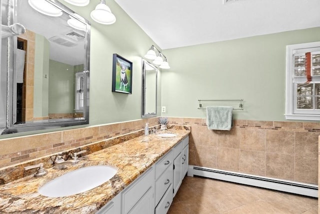 bathroom with tile walls, a baseboard heating unit, vanity, and tile patterned floors