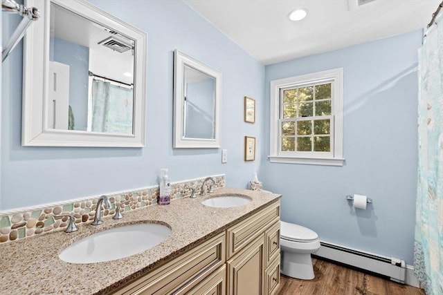 bathroom with a baseboard radiator, wood-type flooring, vanity, and toilet