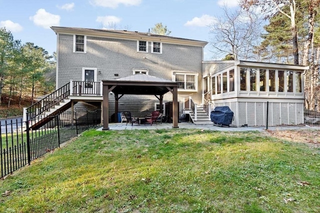 rear view of house featuring a yard, a gazebo, a patio area, and a sunroom