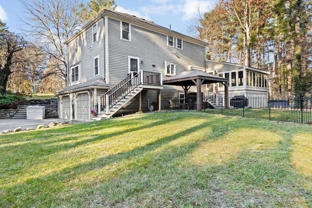 back of property with a garage, a lawn, a sunroom, and a gazebo